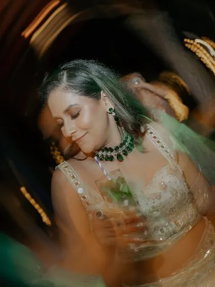 The bride in her element on the dance floor. The swirling lights and motion capture the vibrant energy of the Sangeet night.