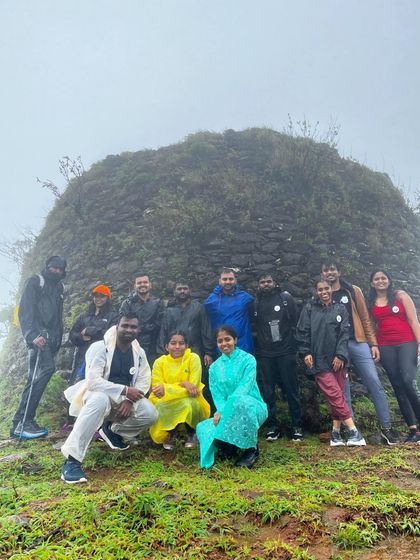 A group photo at a historic stone structure on the Bandaje trail, surrounded by fog.