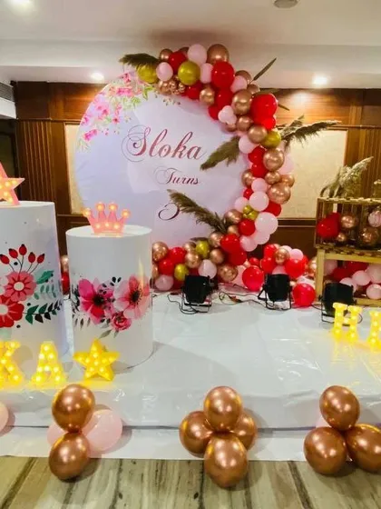 The full view of the floral birthday stage, including personalized marquee letters and decorative props.