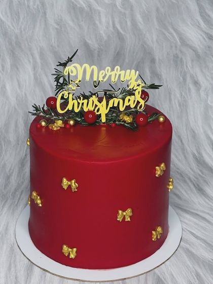 Christmas continues with this elegant red cake. It's decorated with little gold bows and a "Merry Christmas" topper, making it a simple yet festive addition to your holiday celebration.