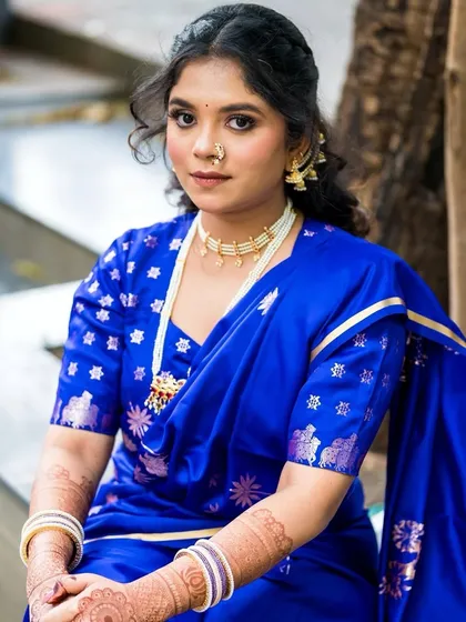A close-up portrait focusing on the elegant pearl necklace and the subtle yet defined eye makeup.