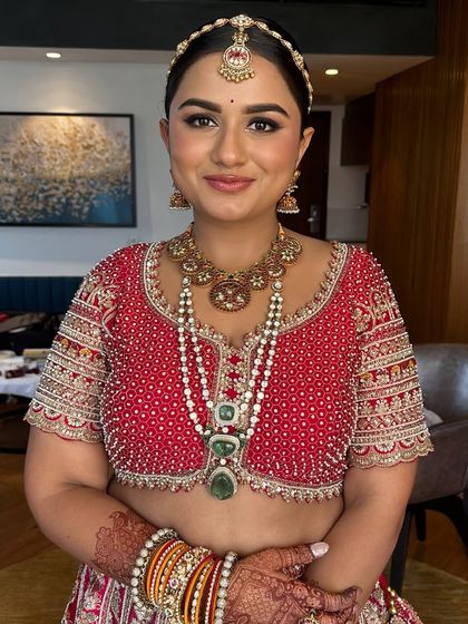 My bride, who trusted my vision completely. We went for a classic look with soft, defined eyes and a flawless base to complement her red and yellow lehenga.