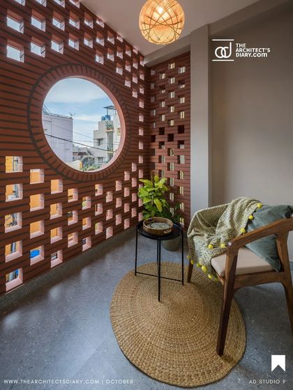 This cozy balcony nook, featured in a publication, highlights how we use natural materials like jute and wood to complement the earthy terracotta jali.