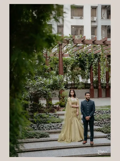 A professional shot of the couple. The bride's makeup looks stunning even from a distance, complementing the elegant outdoor setting.