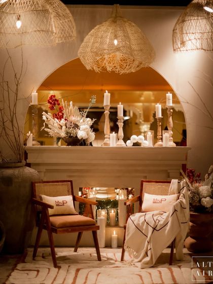 A cozy corner at the 'Muted Melodies' sangeet, complete with a fireplace, personalized cushions, and soft candlelight. Every detail was curated to create a symphony of harmony and cohesion.