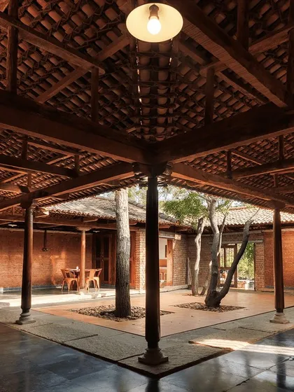 The central courtyard of this rustic organic farm stay is built with traditional techniques using mud and stone. It’s a space designed for community and relaxation, reflecting a commitment to sustainable, eco-friendly living.