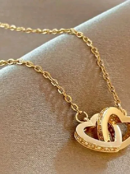 My interlocking hearts necklace, a symbol of connection and love. One heart is smooth while the other is studded with crystals for extra sparkle.
