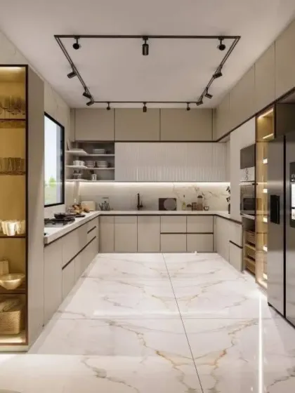 A spacious U-shaped kitchen with marble-tiled floors and a glass-fronted crockery unit. The track lighting provides flexible and focused illumination for the entire space.