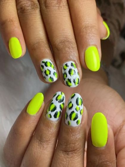 A vibrant neon yellow-green manicure with a fierce leopard print on the accent nails.