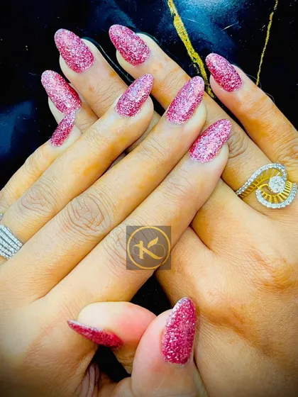 You can never go wrong with a bit of sparkle. This is a full set of almond-shaped nail extensions with a vibrant pink glitter gel polish. It is a perfect look for parties, weddings, or any time you want to feel extra glamorous.