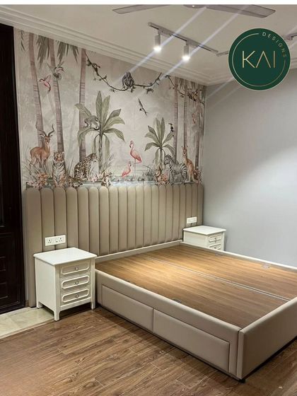 This bedroom features a custom bed with a tall, channel-tufted headboard set against a stunning jungle-themed mural. The neutral upholstery of the bed balances the vibrant wallpaper, creating a unique and adventurous sanctuary.