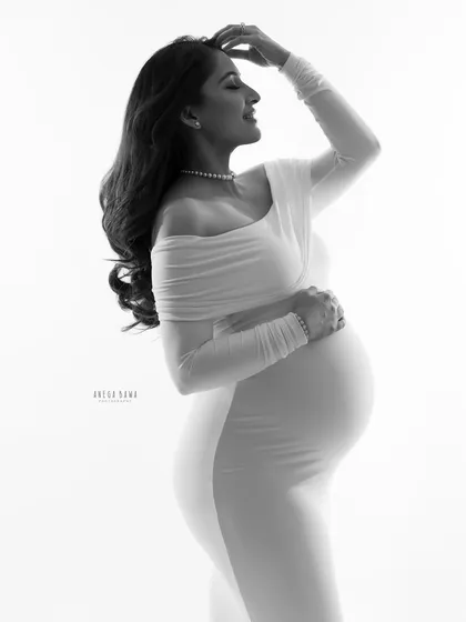 A graceful black and white portrait against a bright background. The high-contrast lighting beautifully sculpts the body and creates a powerful, artistic silhouette.