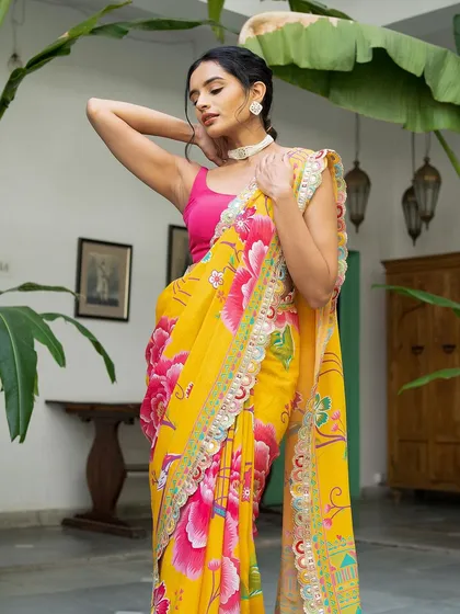 A model looking elegant in a bright yellow saree with a bold pink floral print. The pink blouse provides a lovely contrast, and the overall look is fresh, modern, and perfect for daytime events.
