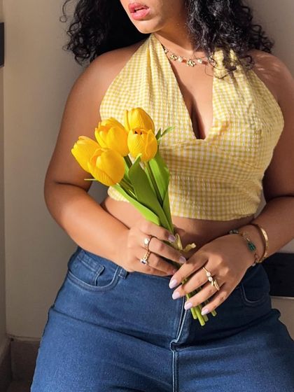 A shot of my full torso, showing how the yellow top is styled with high-waisted jeans.