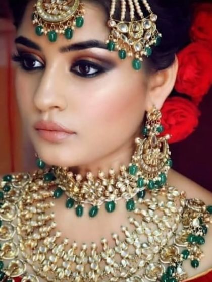 A close-up of a bride wearing a green beaded choker. This shot highlights the intricate craftsmanship of the jewellery.