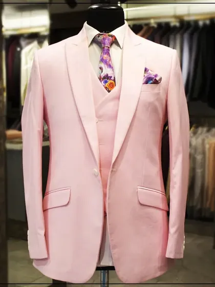 A still shot of the light pink three-piece suit on a mannequin, showcasing its clean cut and modern color.