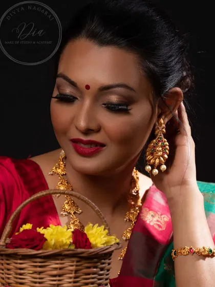 A close-up of the festive makeup, showing the detail in the eye makeup and the beautiful temple-style earrings. The look is both traditional and elegant.