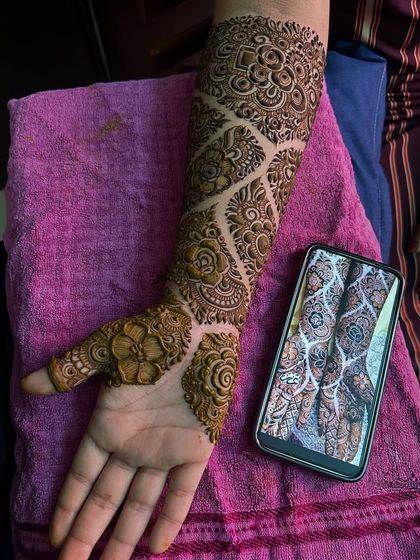 The palm-side view of this intricate engagement mehendi. The design features a beautiful flower on the back of the hand.