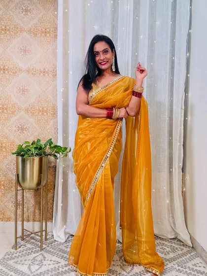 This yellow organza saree with a mirror-work border is perfect for a Haldi ceremony or a daytime wedding event. It's bright, cheerful, and festive.