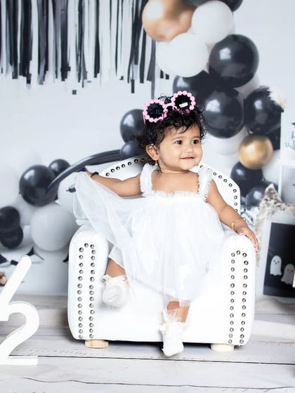 A happy half-birthday girl, posing with her guitar and a chalkboard sign.