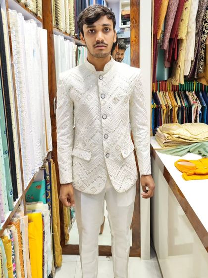 A client in a white Jodhpuri ensemble with intricate mirror work. This outfit blends opulence with comfort, making it a sophisticated choice.