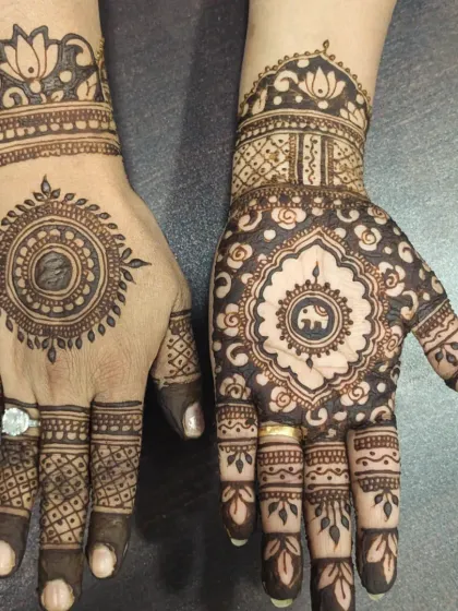 A beautiful example of asymmetrical mehendi. One hand has a large, intricate mandala, while the other features a simpler design, creating a modern and stylish look.