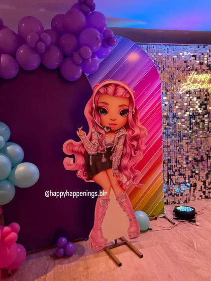 This life-sized cutout of a Rainbow High character adds a huge wow factor to the party decor. It stands next to a rainbow-striped arch panel, making the theme feel larger than life.