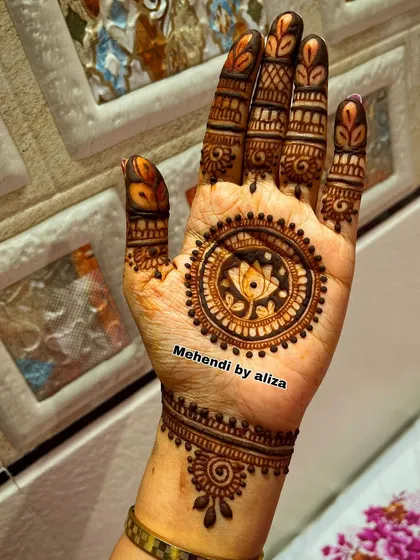 A minimal mehendi design with a central lotus mandala and detailed finger work.