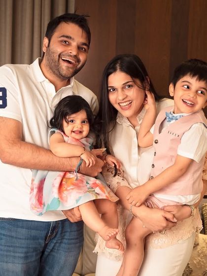 A candid and energetic family photo from a lifestyle session at home. Everyone is smiling and laughing, capturing the happy chaos of life with little ones.