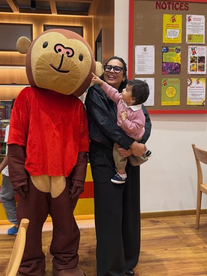 A precious moment of Gauri interacting with the Funky Monkeys mascot. This adorable photo is highly engaging and effectively promotes the brand by showing a child's genuine excitement.