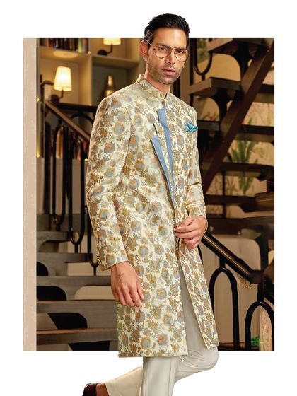 This floral jacquard sherwani features a contemporary asymmetrical placket in a contrasting powder blue. It's a perfect example of how we blend traditional motifs with modern design elements.