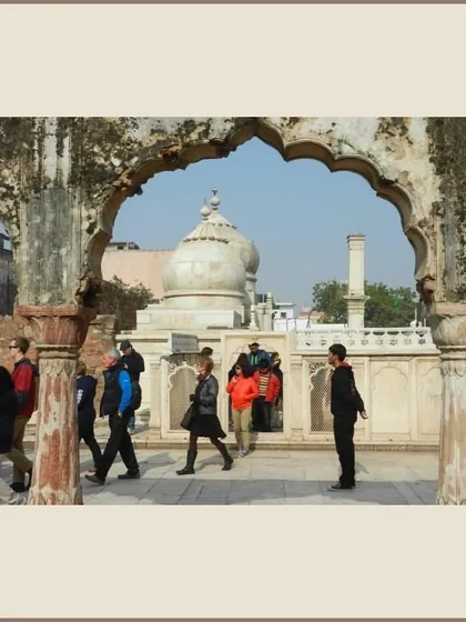 A view of the Moti Masjid within the Qutb Sahib Dargah complex in Mehrauli, framed by a ruined arch. This walk explores the living heritage of one of Delhi's oldest inhabited areas.