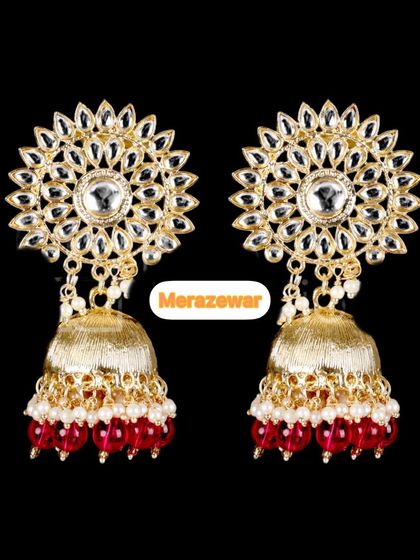 A stunning pair of Kundan jhumkas with red bead drops. The sunflower-like design of the stud is intricate and makes this piece a work of art.