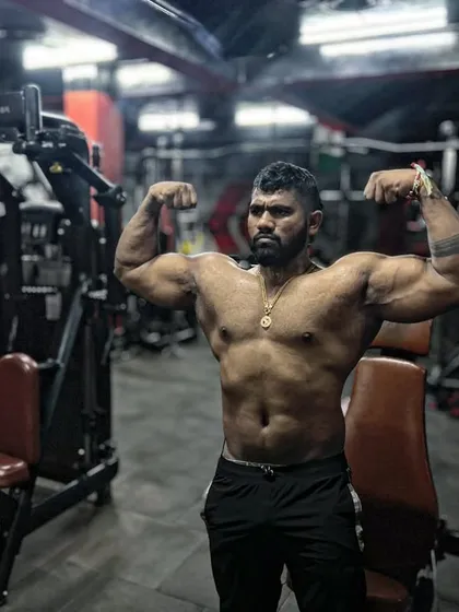 A powerful double bicep pose in the gym. This is a classic bodybuilding pose that showcases overall upper body development.