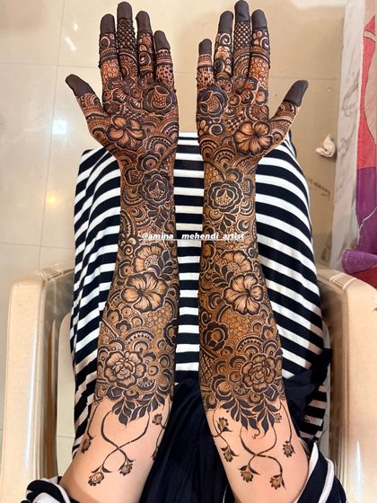 A beautiful design with a vine-like border at the wrist, separating the hand and arm patterns elegantly.