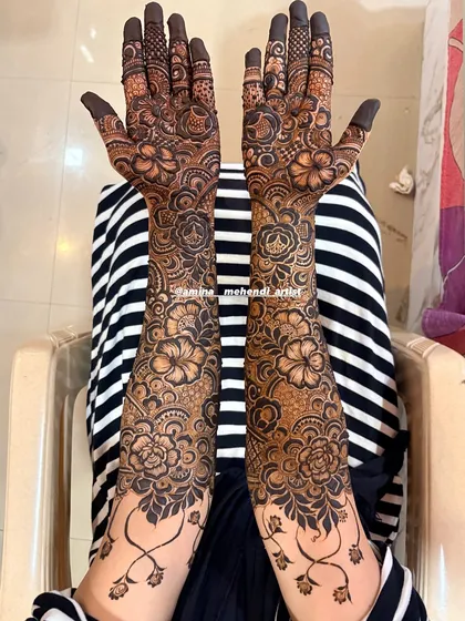 A beautiful design with a vine-like border at the wrist, separating the hand and arm patterns elegantly.