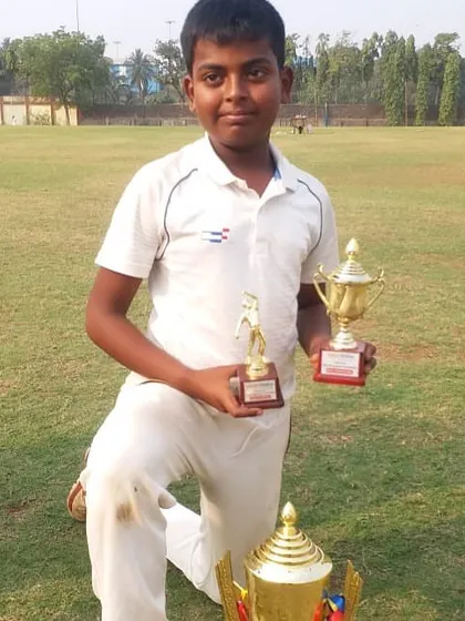 Darshan Rathod posing with his Best Bowler and Man of the Final trophies.