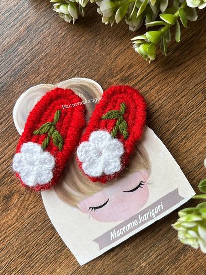 A pair of red hairpins with delicate white flowers. This classic color combination is timeless and adds a pop of color to any hairstyle.