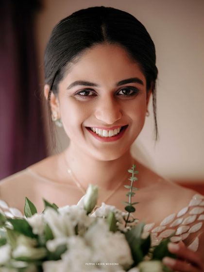 A radiant close-up of the bride, her joyful smile lighting up the frame. This portrait captures the pure happiness of a wedding day.