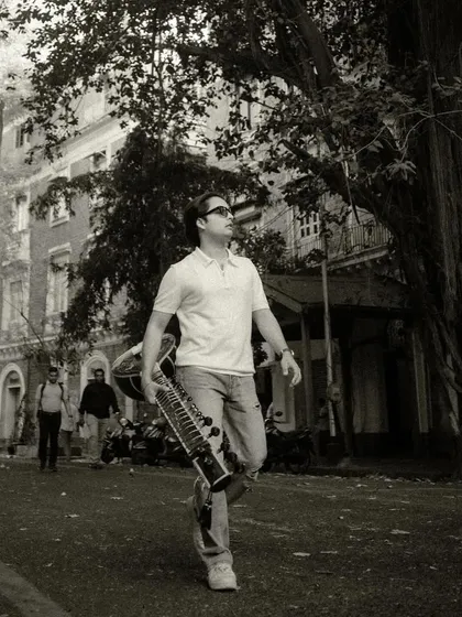 A black and white shot of me walking with my sitar in Mumbai. The city's streets have their own rhythm and story.