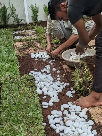 Our team carefully places white pebbles along the pathway border. This detail adds a clean, decorative touch and helps with water runoff.