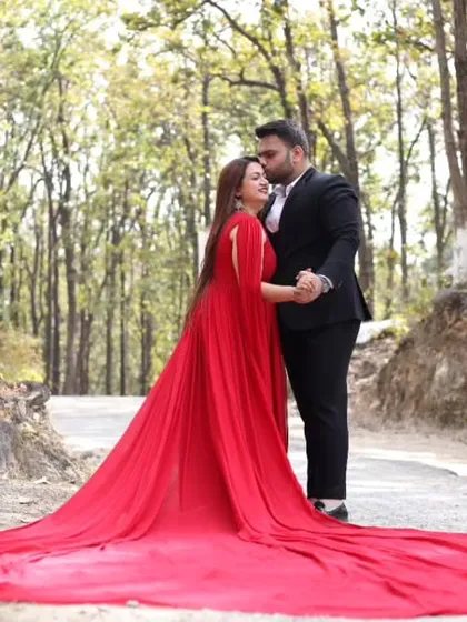 This is the ultimate showstopper gown for a truly magical maternity shoot. The dramatic red trail flows beautifully, creating a stunning contrast against natural backdrops like this forest setting. It's an adjustable infinity gown, ensuring a perfect fit.