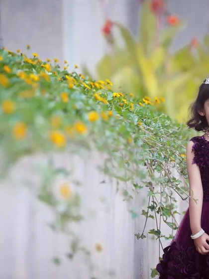 A lovely portrait of the birthday girl in a garden setting. The natural flowers and greenery create a beautiful, soft background.