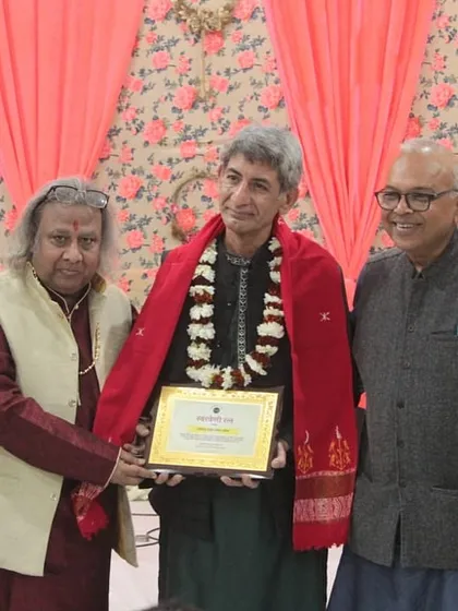 Honoring a senior artist with a plaque and shawl at the 'Raghunathanjali' event.