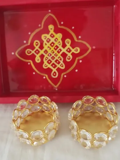 A classic festive combination of a red hand-painted Kolam tray with two crystal T-light holders. This is a popular choice for Diwali gifts, combining tradition with a touch of sparkle.