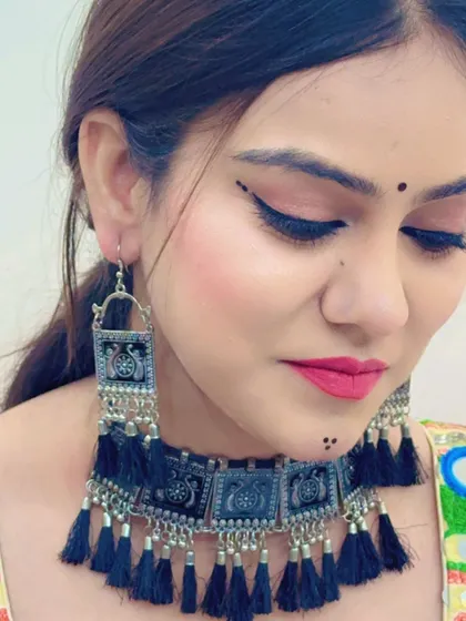 A portrait of the model showing how the black tassel jewellery set pairs with her makeup and overall festive look.