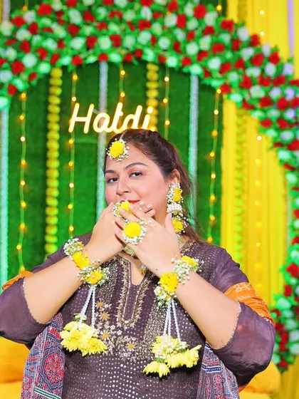 This playful shot from a Haldi ceremony shows the floral haath phool and earrings up close. The yellow flowers are perfect for the occasion.
