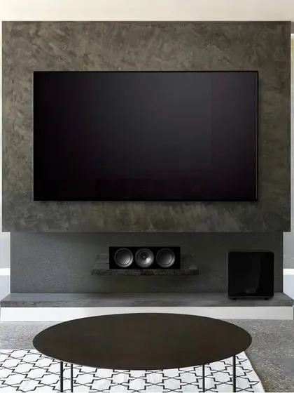 This modern living room features a full KEF surround sound system. The slim tower speakers, matching center channel, and subwoofer are arranged to provide an immersive soundstage for movies, all while maintaining a clean, minimalist look.