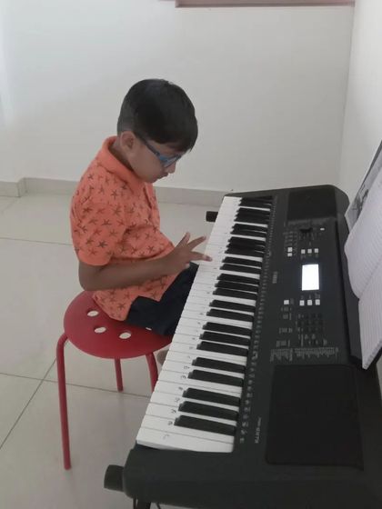 A young student diligently practicing his keyboard lesson.