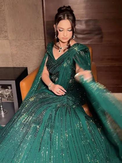 The full look in motion. The dramatic eye makeup and the sparkling green saree create a look that is pure magic.